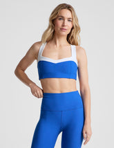 blue self-lined, medium to low support bra top with a colorblock sweetheart neckline panel, contrast straps, and princess seams. bra is paired with blue high-waisted midi leggings.